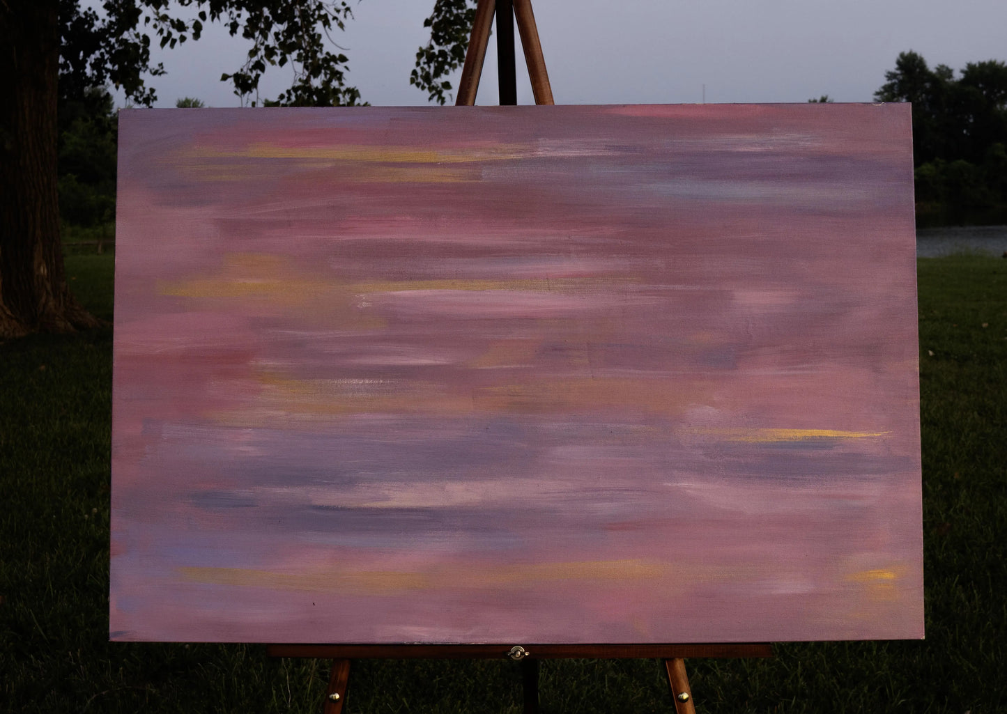 Abstract painting with horizontal strokes of blended pink, lavender, gold, and muted purple. The soft, layered colors create a hazy, dreamlike effect, evoking movement and blurred vision, as if the world is rushing past.