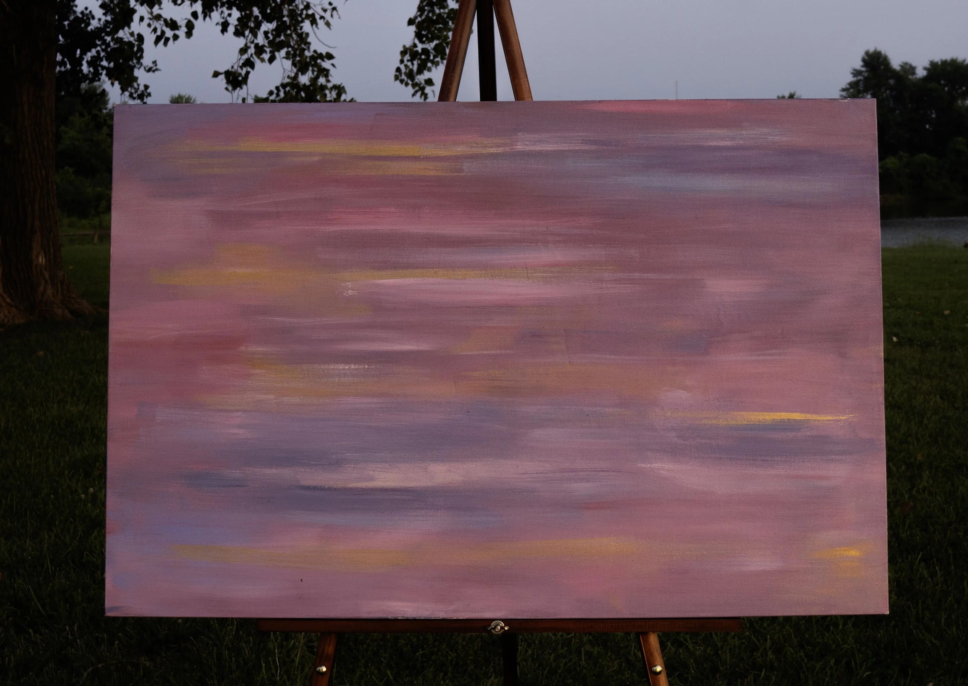 Abstract painting with horizontal strokes of blended pink, lavender, gold, and muted purple. The soft, layered colors create a hazy, dreamlike effect, evoking movement and blurred vision, as if the world is rushing past.